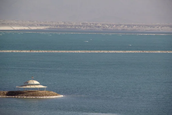 Mar Morto con cristalli di sale e ombrellone sulla spiaggia — Foto Stock