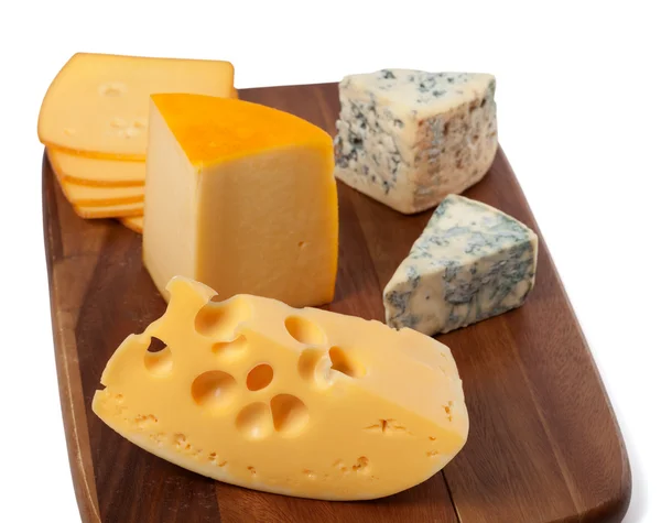 Different types of cheese on wooden board — Stock Photo, Image