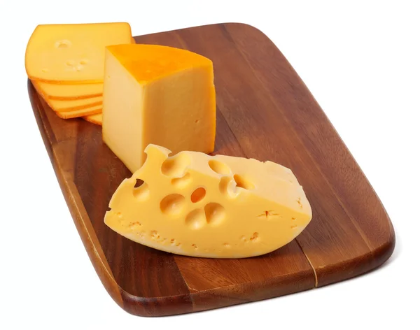 Cheeses on wooden kitchen board — Stock Photo, Image