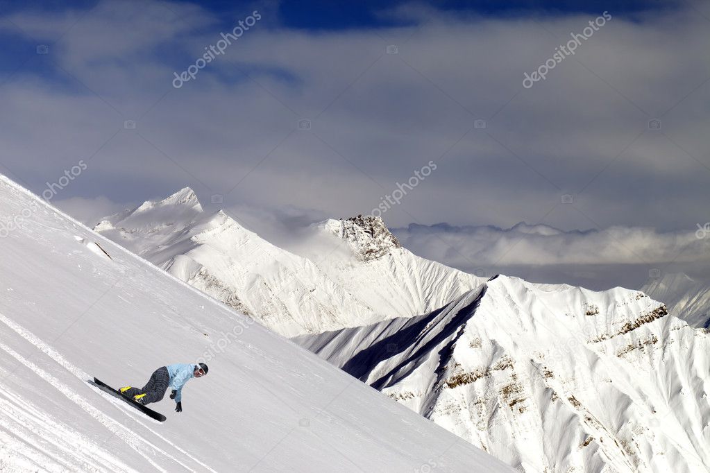 Snowboarder on off-piste slope in mountains