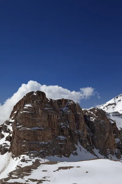 Rocas en la nieve y el azul cielo — Foto de Stock