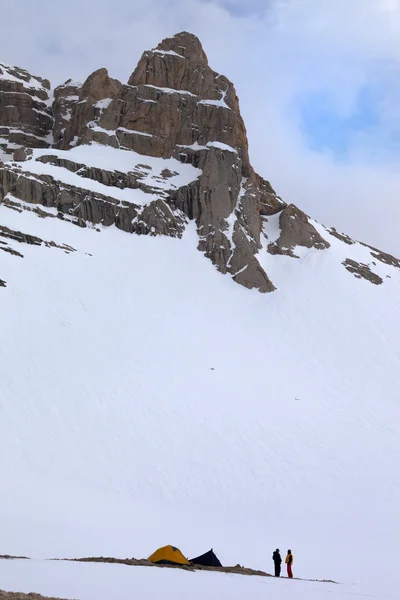 Tents and hikers in snow mountains — Stock Photo, Image