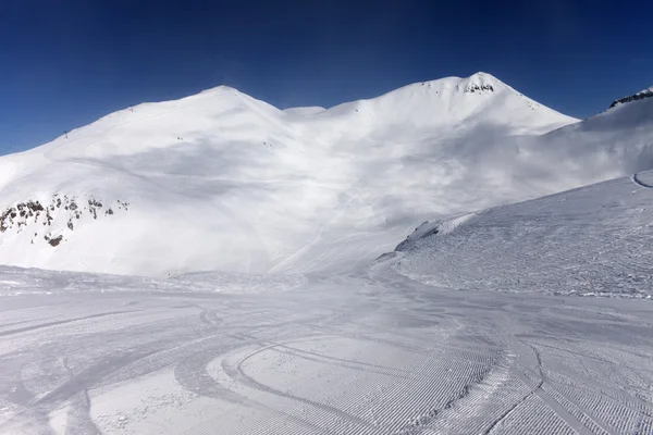 Skipiste met sneeuwscooter trail — Stockfoto