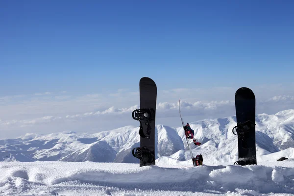 Tři snowboardy ve sněhu u mimo sjezdovku svahu v den slunce — Stock fotografie