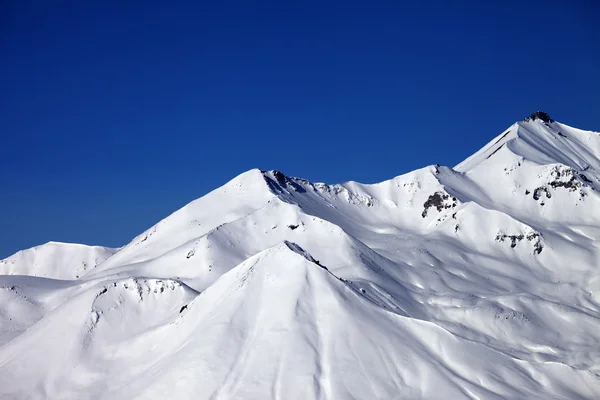 Havas téli hegyek és a tiszta kék ég, nap nap — Stock Fotó