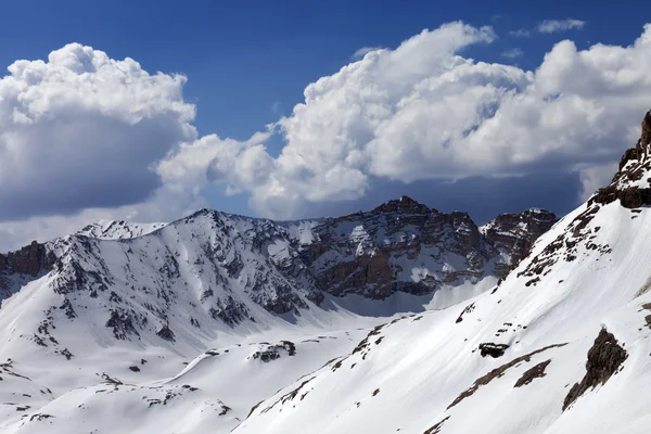 雪に覆われた山々 と晴れた春の日の雲と青空 — ストック写真