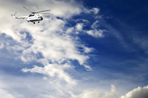 Helicopter in blue sky with clouds — Stock Photo, Image