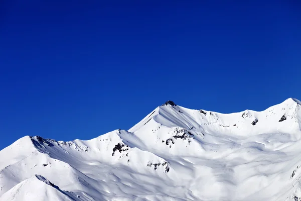 Pendiente fuera de pista y azul cielo despejado en invierno agradable —  Fotos de Stock