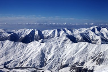Gökyüzü bulutlu ve karlı dağlar