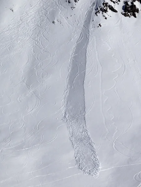 Au large de la pente de la piste avec traces de skis, planche à neige et avalanche — Photo