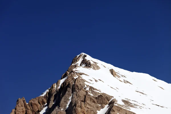 Cima de la montaña con nieve y un cielo azul despejado en buen día — Foto de Stock