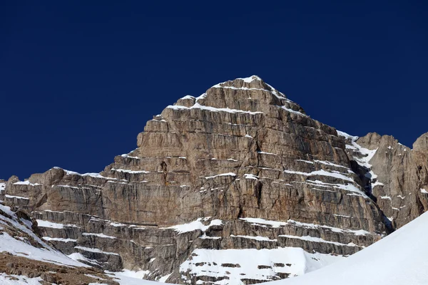 Rocas en la nieve y un cielo azul claro — Foto de Stock