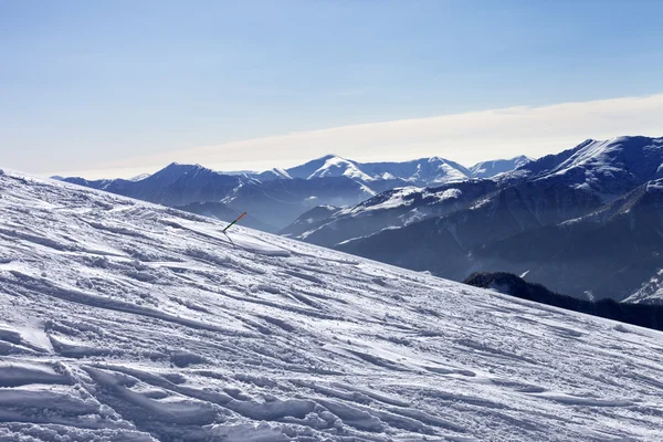 Горнолыжный склон с след от лыж, сноубордов и горы в дымке — стоковое фото
