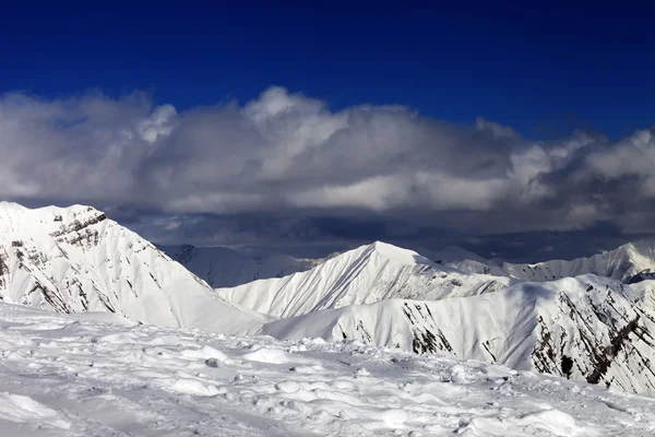 Sjezdovka a krásné zasněžené hory v mracích. — Stock fotografie
