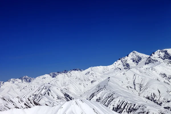 Montañas de invierno cubierto de nieve y un cielo azul — Foto de Stock