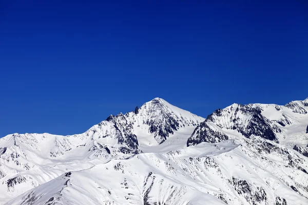 겨울 눈 덮인 산, 푸른 맑은 하늘winter besneeuwde bergen en blauwe heldere hemel — Stockfoto