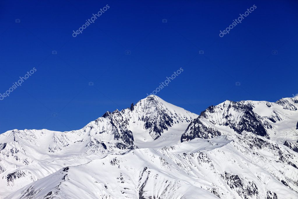 Winter snowy mountains and blue clear sky