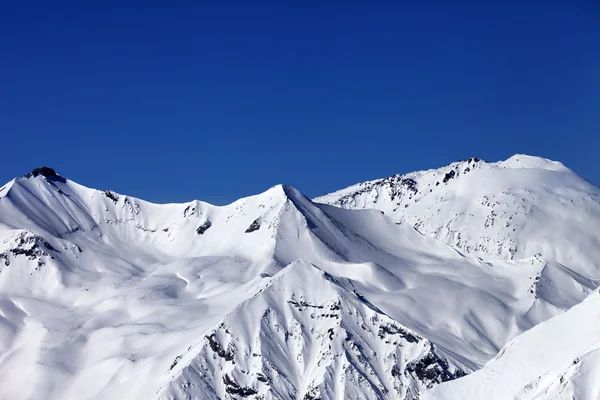 Pendiente de pistas nevadas y cielo azul claro —  Fotos de Stock