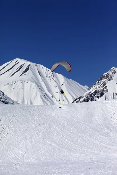 Skydiver landing on ski slope — Stock Photo, Image
