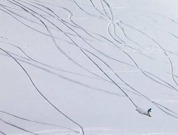 Snowboardista z kopce na mimo svah sjezdovky s nově padlý sníh — Stock fotografie