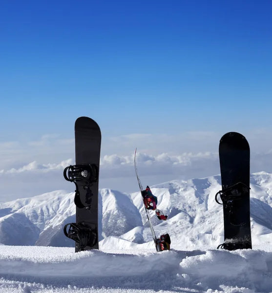 Trois planches à neige dans la neige près de pente de piste dans la journée du soleil — Photo