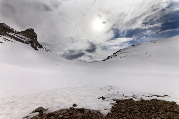Paso de montaña cubierto de nieve y un cielo con nubes en la noche —  Fotos de Stock
