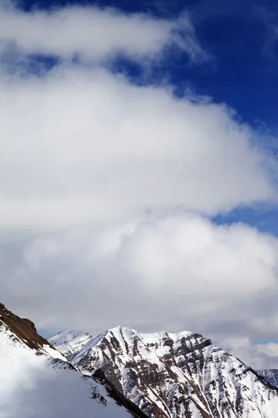 Montañas de invierno cubierto de nieve y un cielo con nubes en el día del sol —  Fotos de Stock