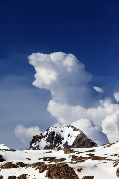 Rocas en la nieve y el azul cielo con nubes — Foto de Stock