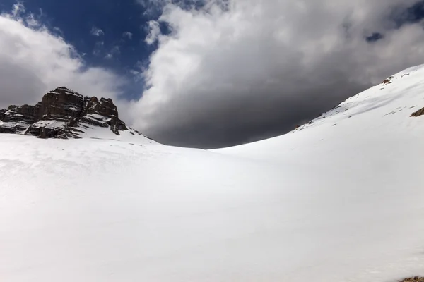 Paso de montaña cubierto de nieve y un cielo con nubes de tormenta —  Fotos de Stock