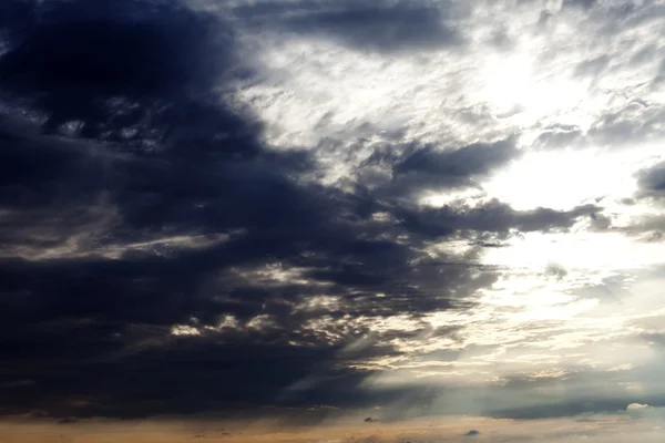 Sun on sky and dark storm clouds — Stock Photo, Image