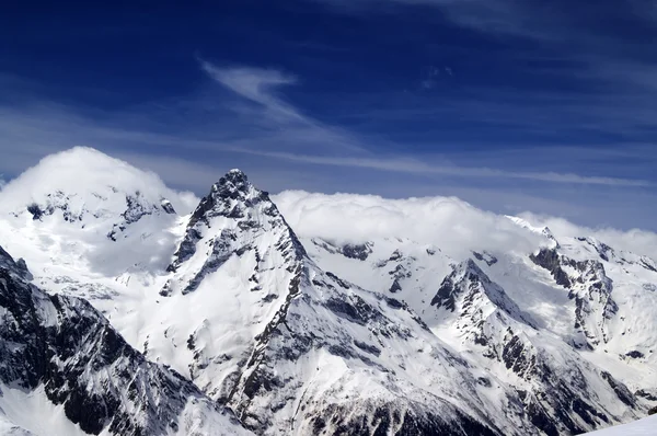 Montagnes enneigées et ciel bleu avec des nuages — Photo