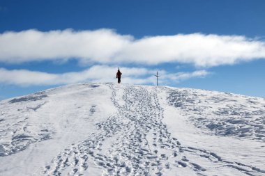 Omzunda kayaklarla kayakçı güzel bir güneş gününde dağın zirvesine çıkar. Kışın Kafkas Dağları, Gürcistan, Gudauri bölgesi, Kudebi Dağı.