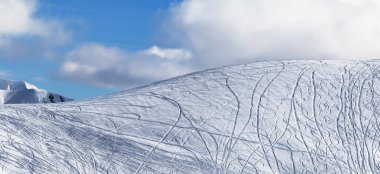Kar yamacındaki panoramik manzara kayaklardan, kar kayaklarından ve mavi gökyüzünden güneşli kış günlerinde hava bulutlu. Kafkasya Dağları, Gürcistan, Gudauri bölgesi.