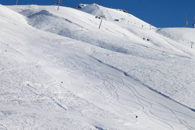 Karlı kayak yamacı. Güneşli bir günde kayak yapmak. Gürcistan, Gudauri bölgesi. Kışın Kafkas Dağları.