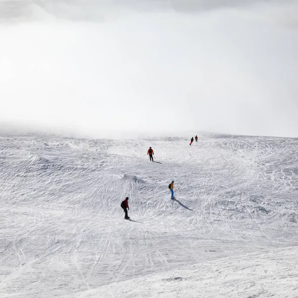 Skidåkare Och Snowboardåkare Utför Snöig Sluttning Och Solljus Himmel Dimma — Stockfoto
