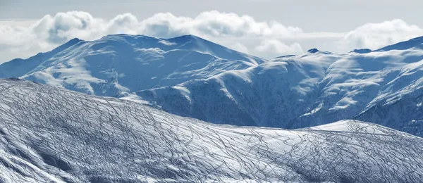 スキーやスノーボードからの痕跡や 冬の日の朝に雲の中に雪の山を自由にするための非圧雪バーンのパノラマビュー コーカサス山脈 ジョージア州 グドーリ地方 — ストック写真