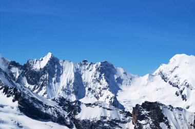 Kış karlı dağlar ve soğuk güneş gününde güzel mavi gökyüzü. Kafkas Dağları, Dombay bölgesi. 
