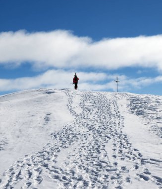 Omzunda kayaklarla kayakçı güneşli bir günde karlı dağın zirvesine çıkar. Kışın Kafkas Dağları, Gürcistan, Gudauri bölgesi, Kudebi Dağı.
