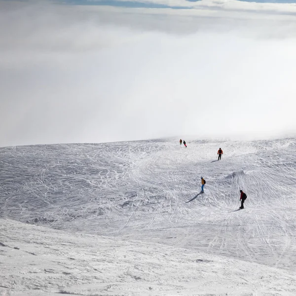 Σκιέρ Και Snowboarders Κατηφόρα Χιονισμένη Πλαγιά Και Τον Ουρανό Ηλιοφάνειας — Φωτογραφία Αρχείου