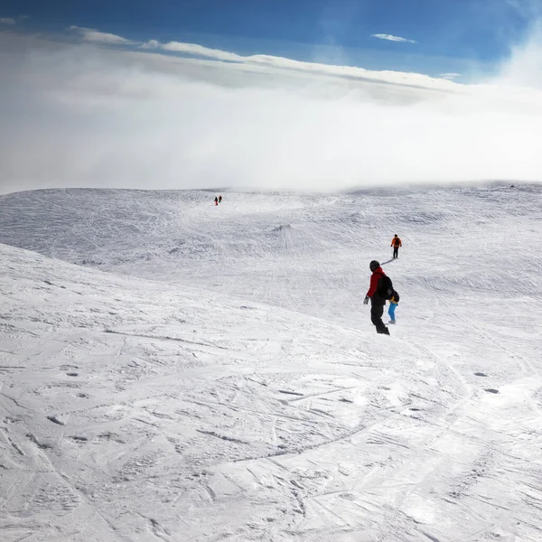 Kayakçılar Snowboardcular Kar Yamaçlarında Gökyüzünde Güneş Işığı Bulutlarıyla Kış Gününde — Stok fotoğraf