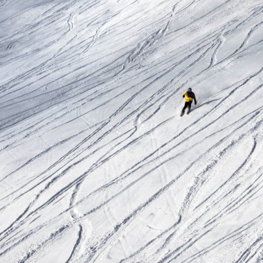 Kar yamacında kayakçı kar yağışından sonraki kış güneşli havada serbest dolaşmak için aşağıya iniyor.
