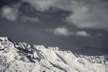 Siyah ve beyaz kış karlı dağlar ve bulutlu gökyüzü güneşli bir günde. Kafkas Dağları. Gürcistan 'ın Svaneti bölgesi.