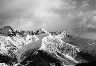 Karlı kış dağı ve akşamları bulutlu gökyüzü. Kafkas Dağları. Gürcistan 'ın Svaneti bölgesi. Siyah ve beyaz tonlu manzara.