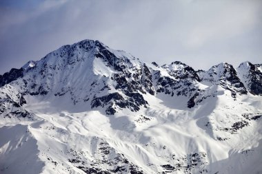 Kar, güneş ışığı dağı ve akşamları gri gökyüzü. Kafkas Dağları. Gürcistan 'ın Svaneti bölgesi.