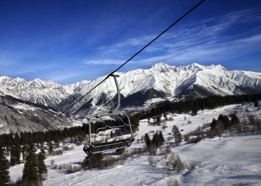 Chair-lift at ski resort and snow winter mountains at nice sun day. Caucasus Mountains. Hatsvali, Svaneti region of Georgia. clipart