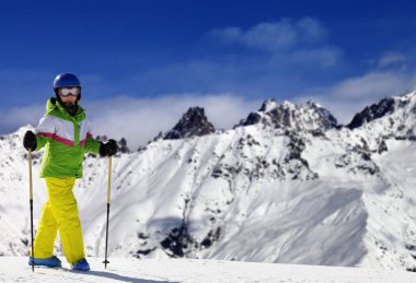 Güneş kış gününde kar dağlarında kayak direkleri olan genç bir kayakçı. Kafkas Dağları. Gürcistan 'ın Svaneti bölgesi.