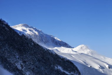 Piste yakın olmayan yamaçlar ve kış sabahında açık mavi gökyüzü. Büyük Kafkaslar, Shahdagh, Azerbaycan.