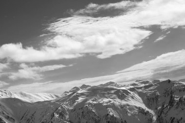 Snowy mountains and sunlight sky with clouds at winter evening. Caucasus Mountains. Svaneti region of Georgia. Black and white toned landscape