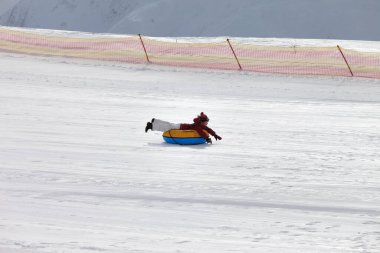 Genç kız kar üzerinde yokuş aşağı kayak merkezinde kış günü karlı dağlarda