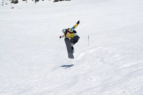 Snowboarder Springen Besneeuwde Skipiste Bij Hoge Winterbergen Zon Koude Dag — Stockfoto